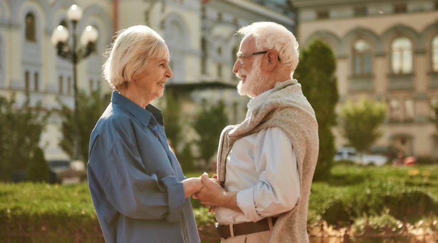 You are my sunshine. Happy and beautiful elderly couple holding hands and looking at each other with