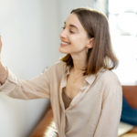 woman standing near the heat regulator at home 2021 09 01 12 16 26 utc