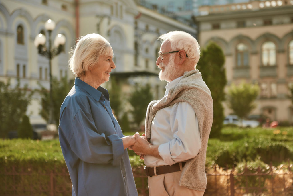 You are my sunshine. Happy and beautiful elderly couple holding hands and looking at each other with