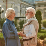 You are my sunshine. Happy and beautiful elderly couple holding hands and looking at each other with