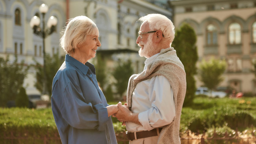 You are my sunshine. Happy and beautiful elderly couple holding hands and looking at each other with