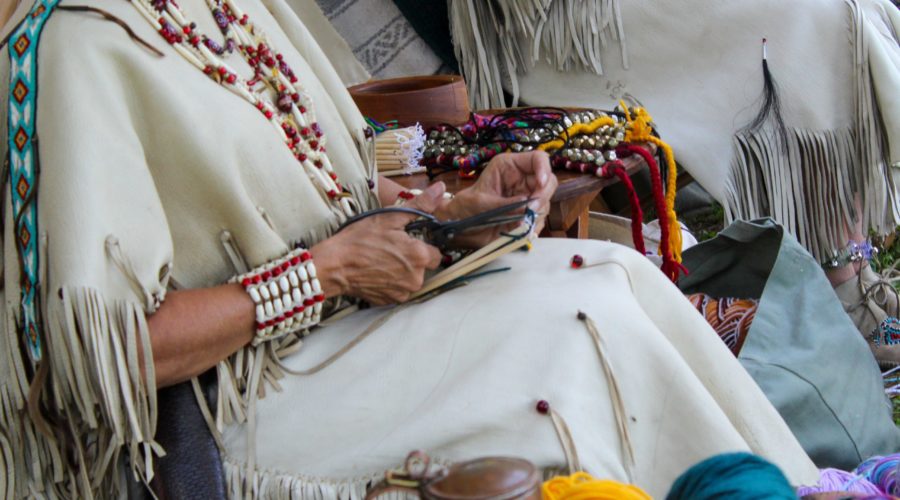 The History of Native American Clothing 4 native american indians making string jewelry 2021 10 23 03 13 39 utc scaled