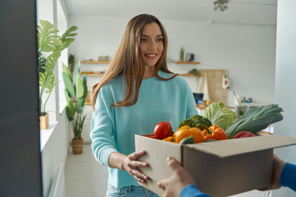 happy young woman accepting box with groceries fro 2022 10 28 05 39 38 utc